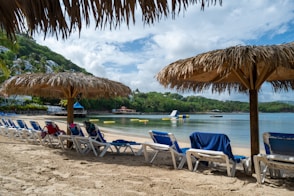 a row of beach chairs sitting on top of a sandy beach