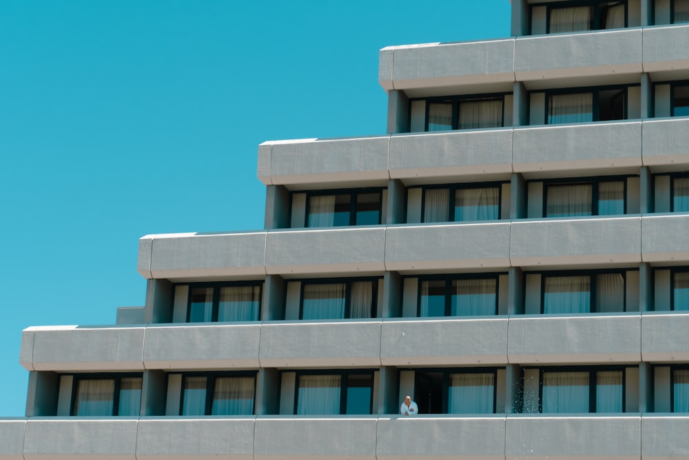 a person standing on a ledge in front of a building