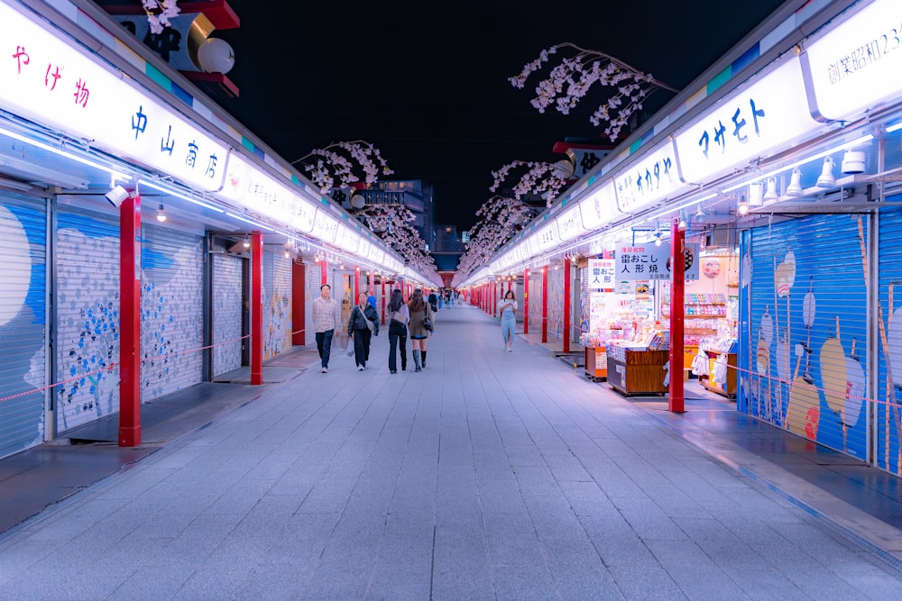 a group of people walking down a street at night