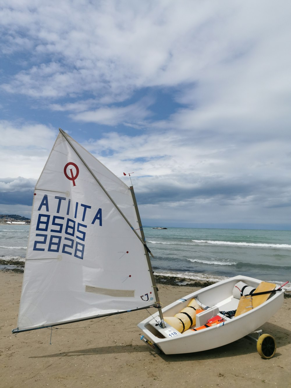 a sailboat on the beach with a sign on it
