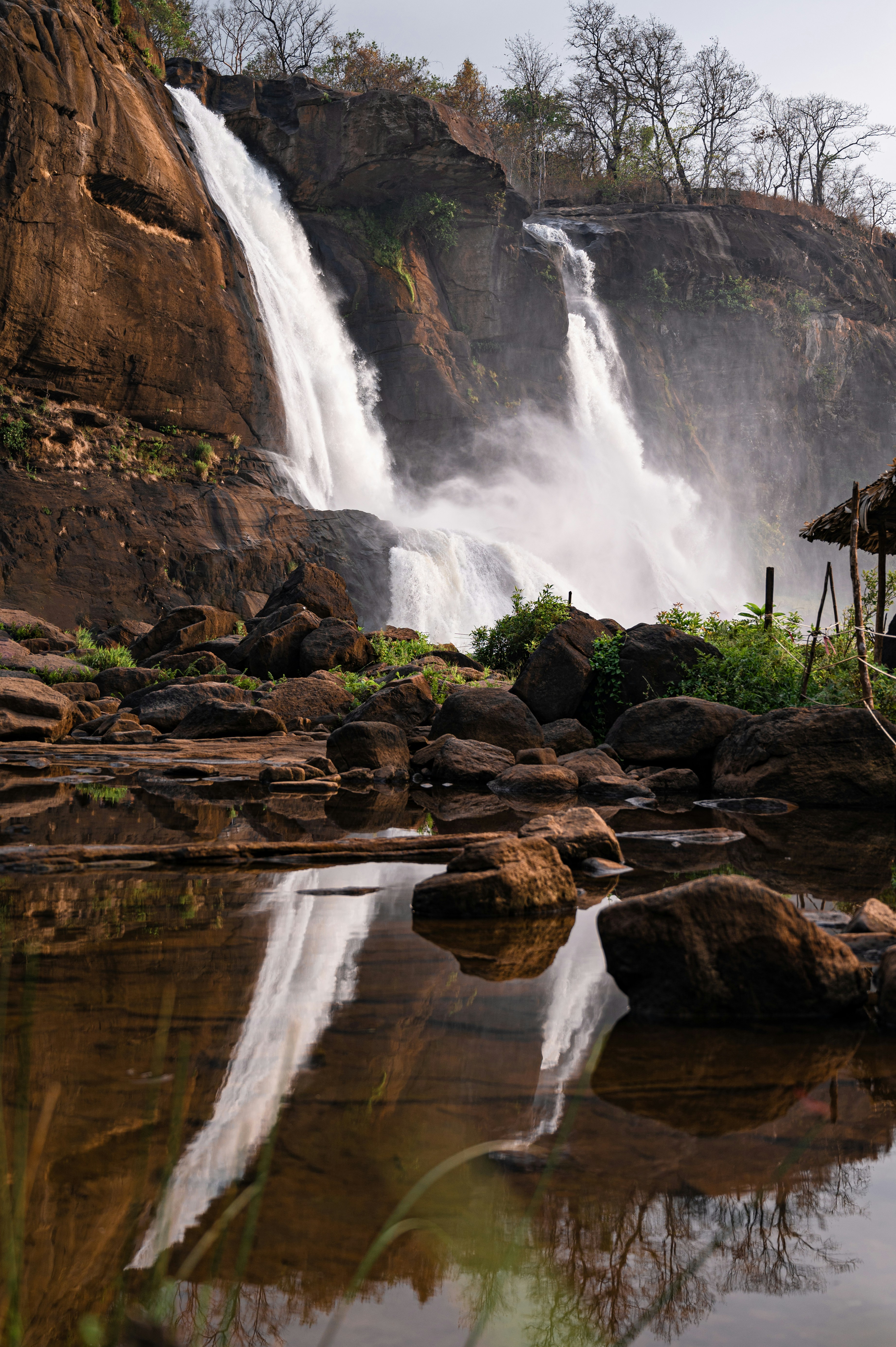 a large waterfall with a wooden structure in front of it