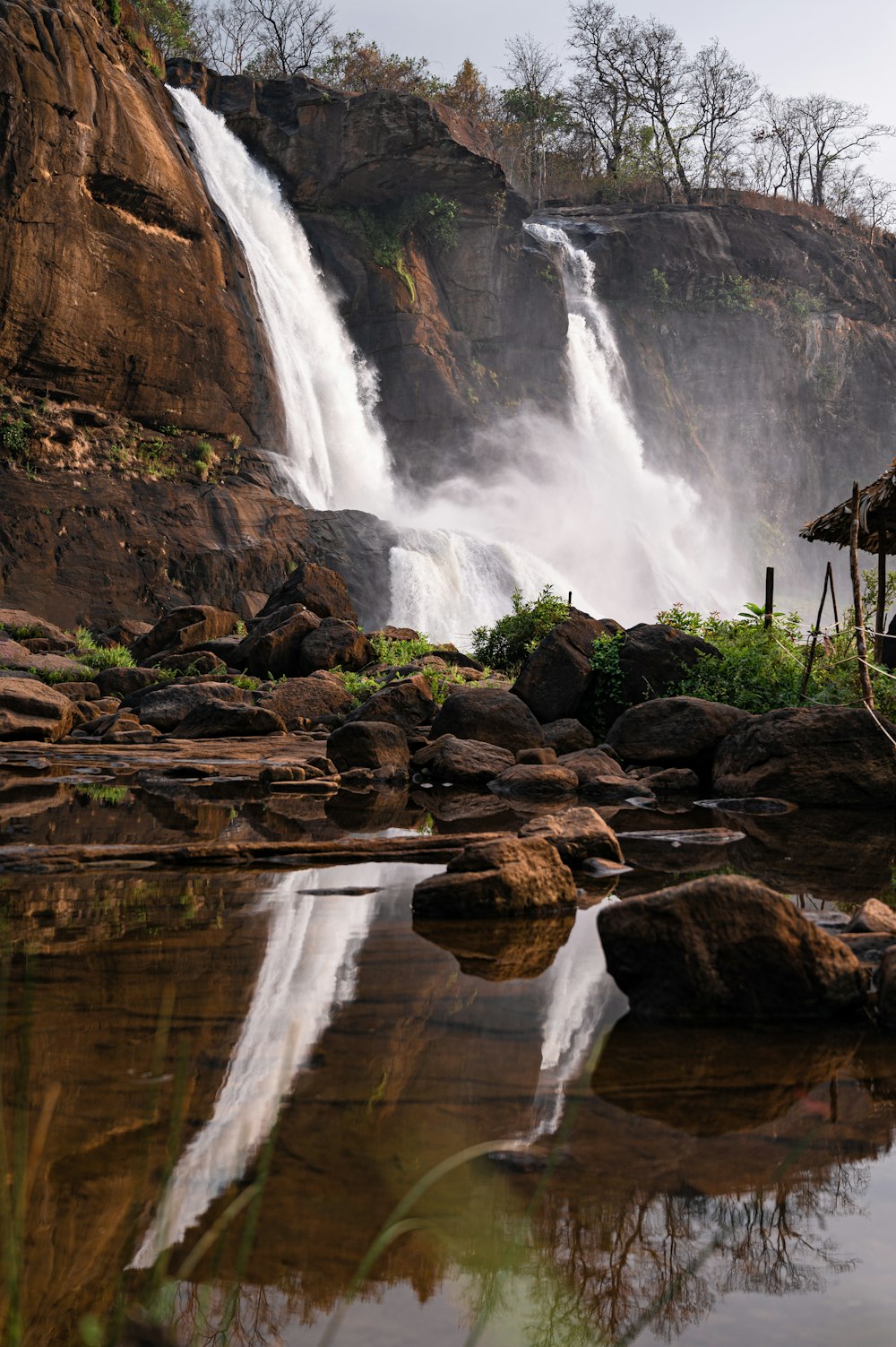 a large waterfall with a wooden structure in front of it