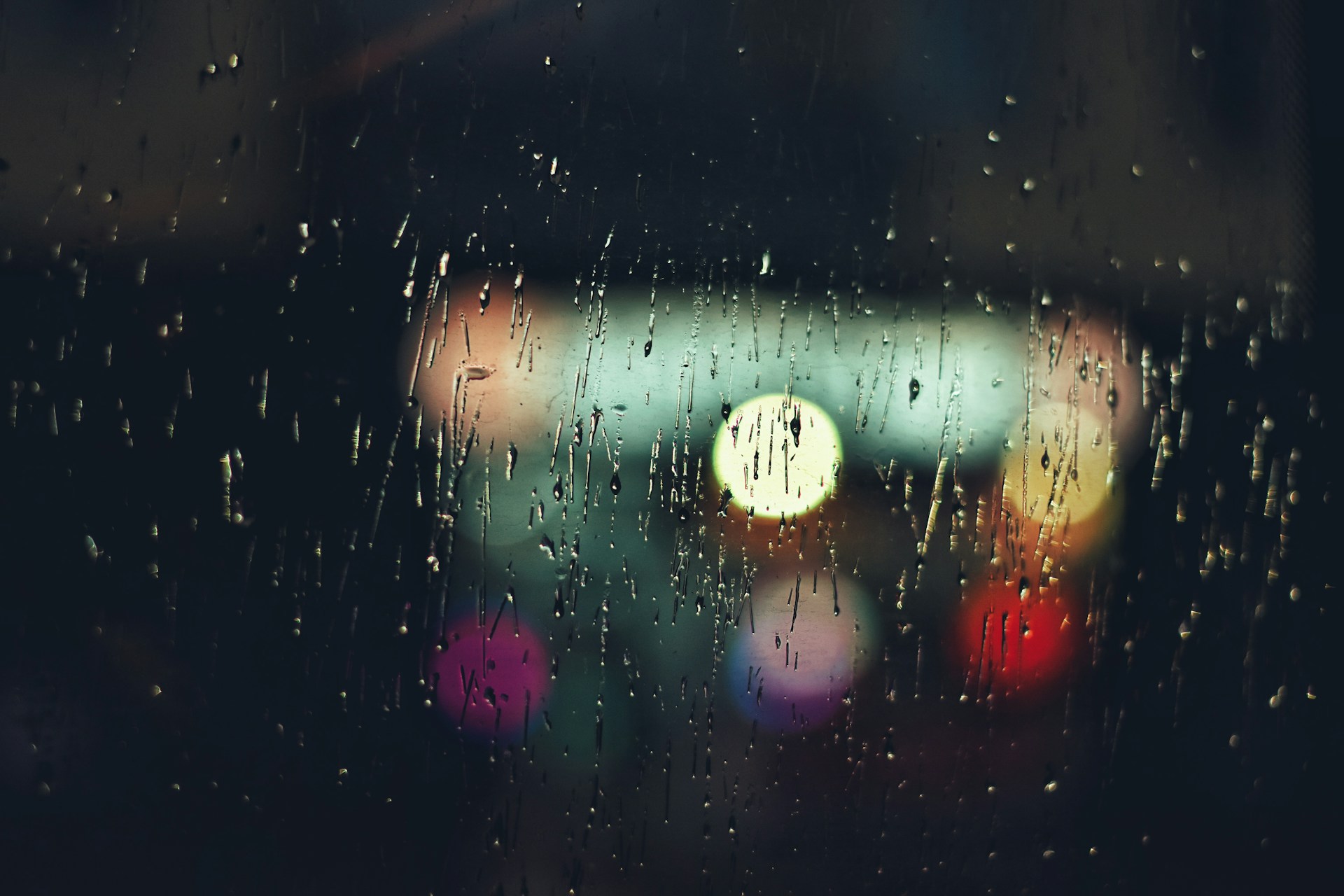 a blurry image of a street light seen through a rain covered window