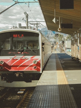 a red and white train pulling into a train station