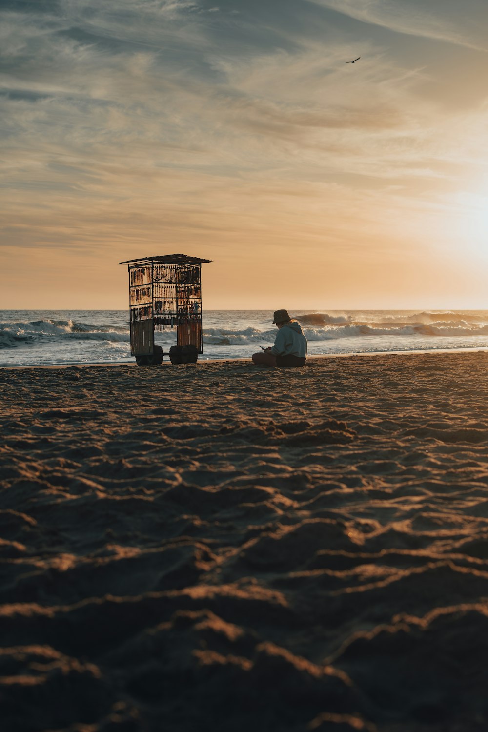 a couple of people sitting on top of a sandy beach