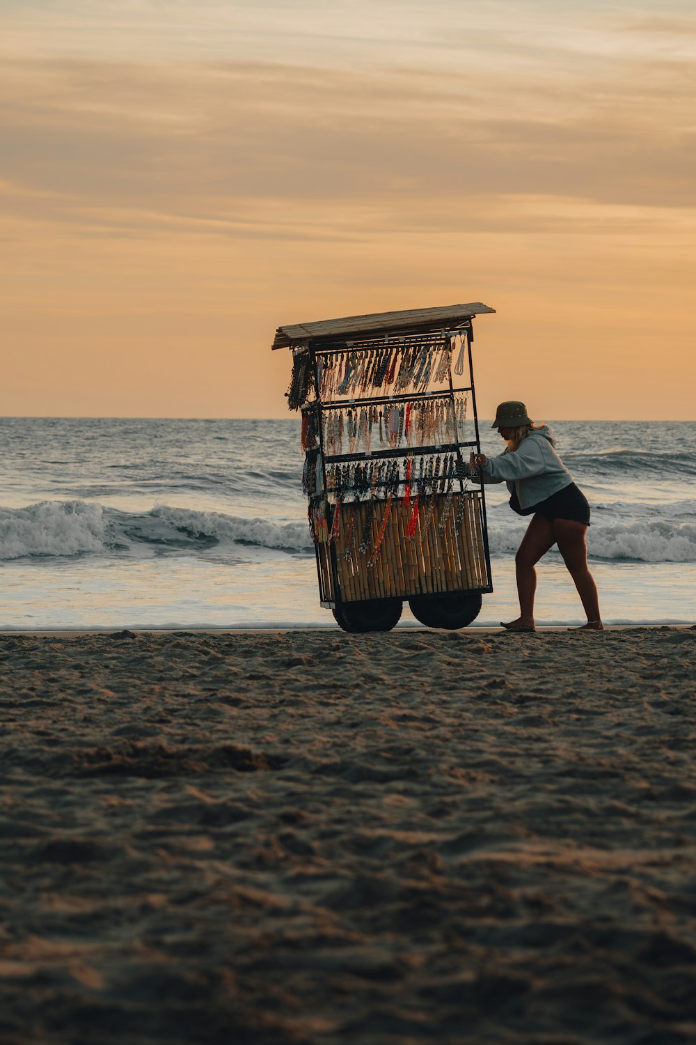 a woman pushing a cart on the beach