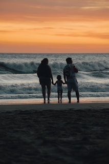a group of people standing on top of a sandy beach