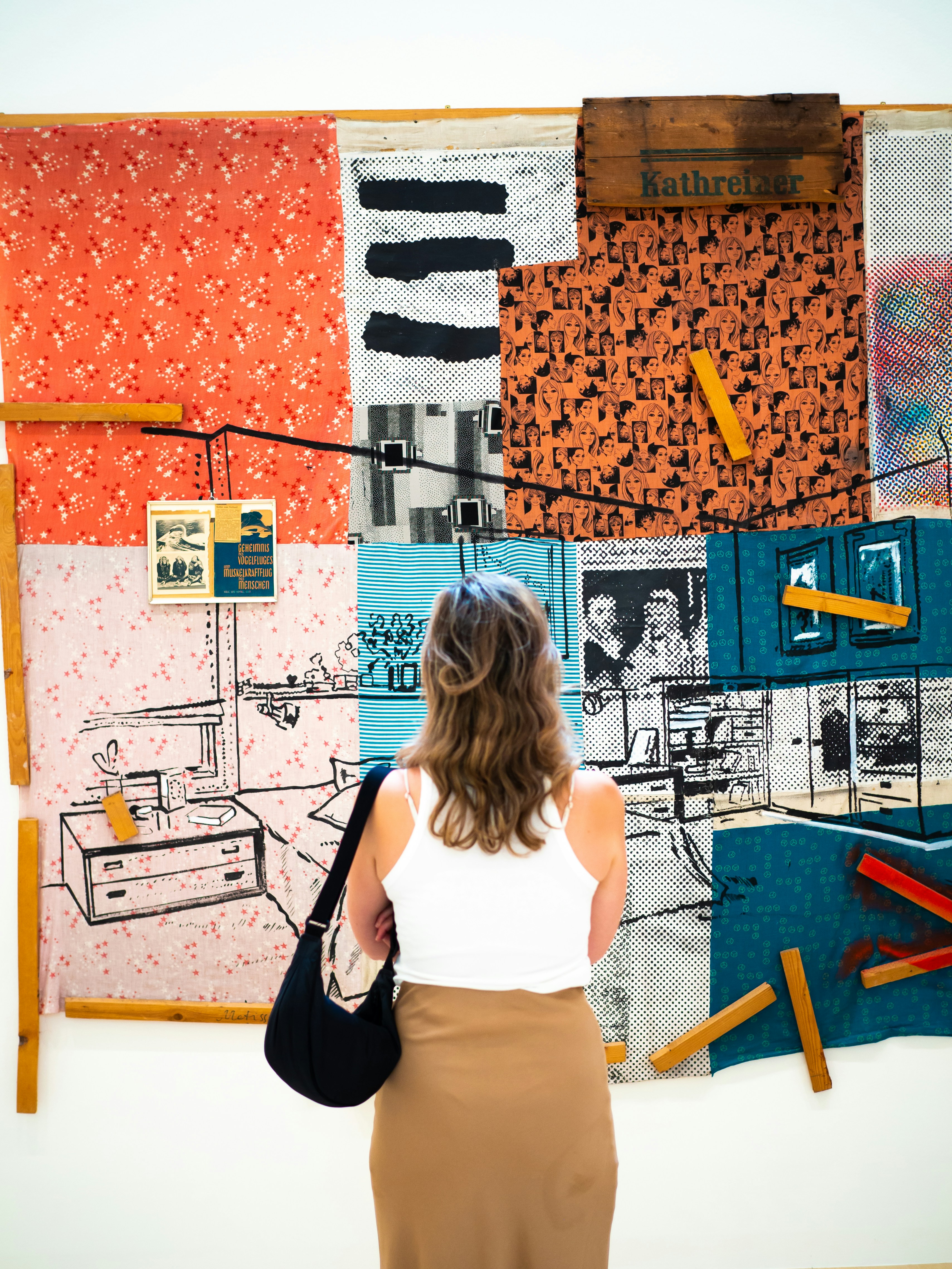 a woman standing in front of a wall covered in art