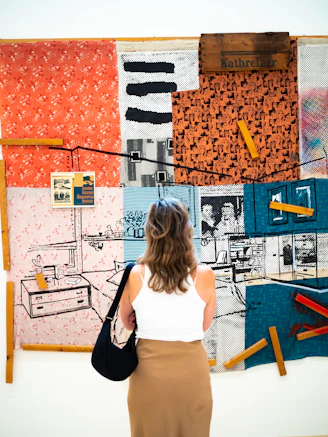 a woman standing in front of a wall covered in art