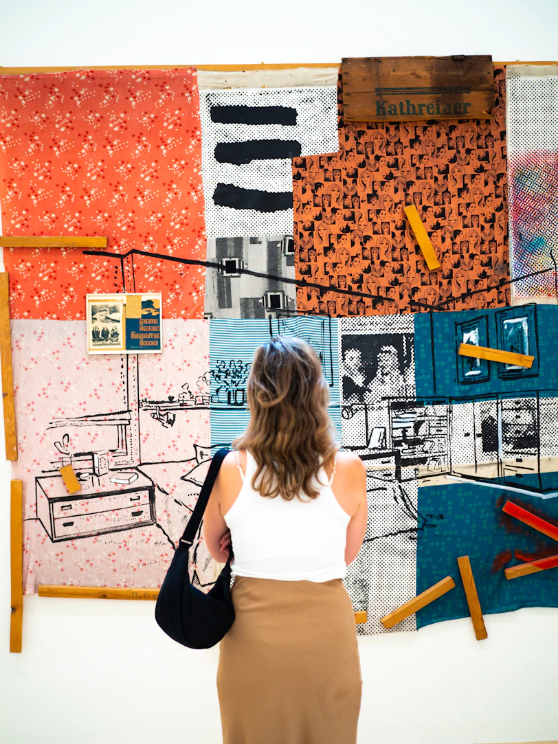 a woman standing in front of a wall covered in art