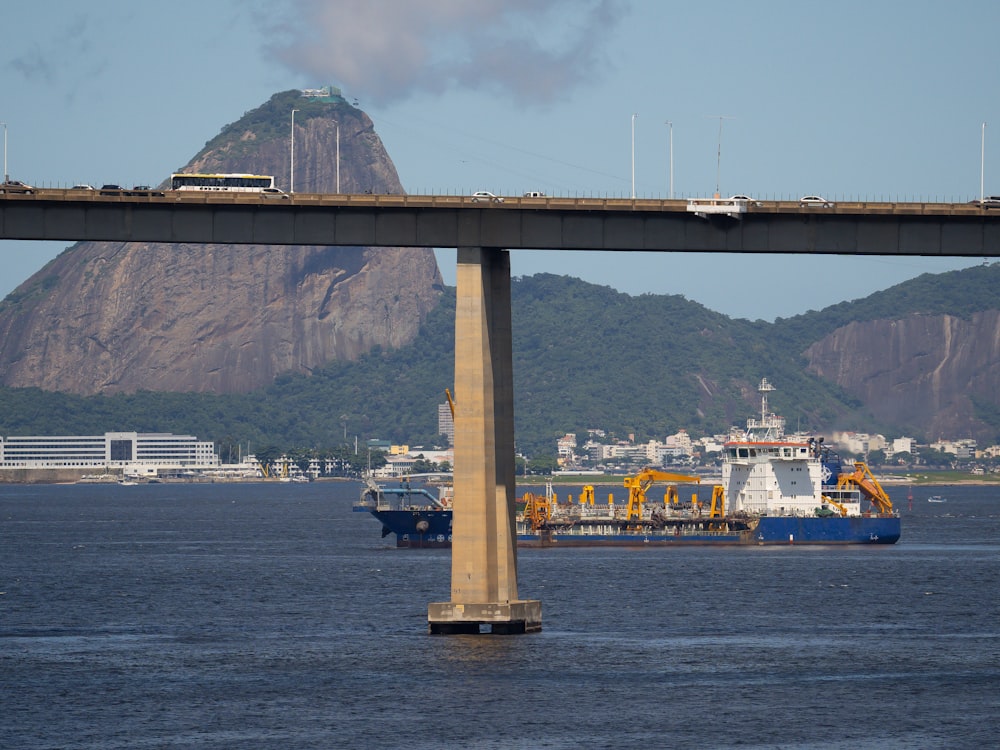 a bridge over a body of water with a mountain in the background