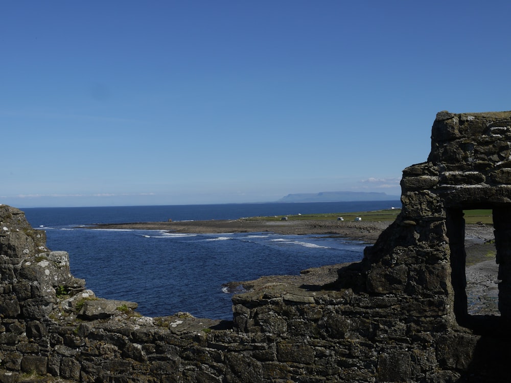 a view of a body of water from a stone wall