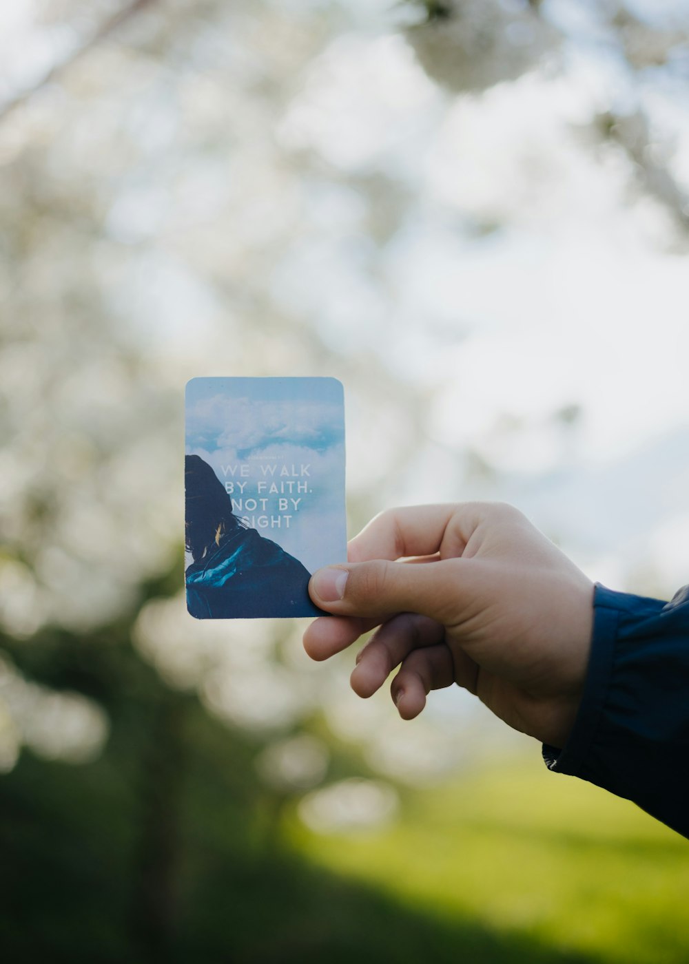 una mano sosteniendo una tarjeta con la imagen de una montaña