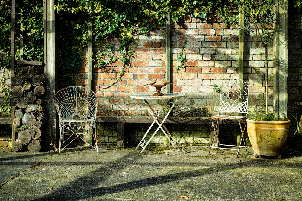 a table and chairs sitting next to a brick wall