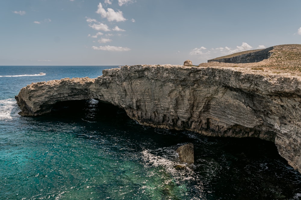 a rocky cliff overlooks a body of water