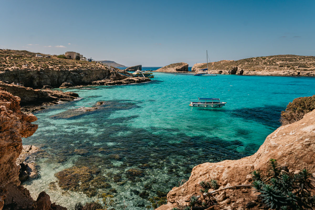 Boat in the clear turquoise water of the Blue Lagoon, Comino