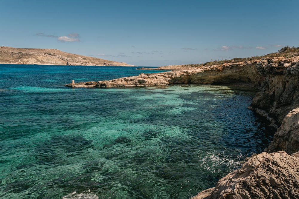 a body of water near a rocky shore