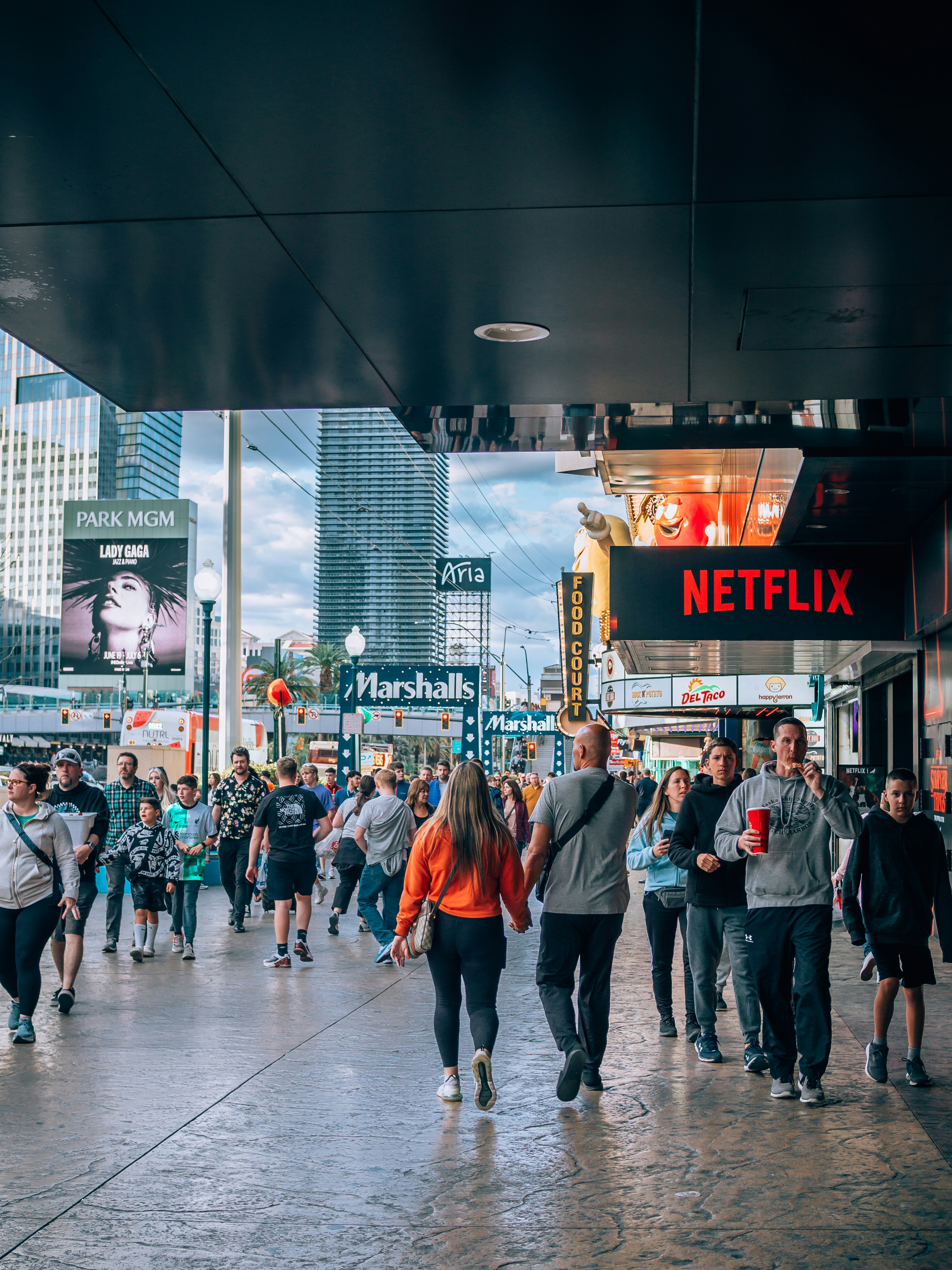 a group of people walking down a street next to tall buildings