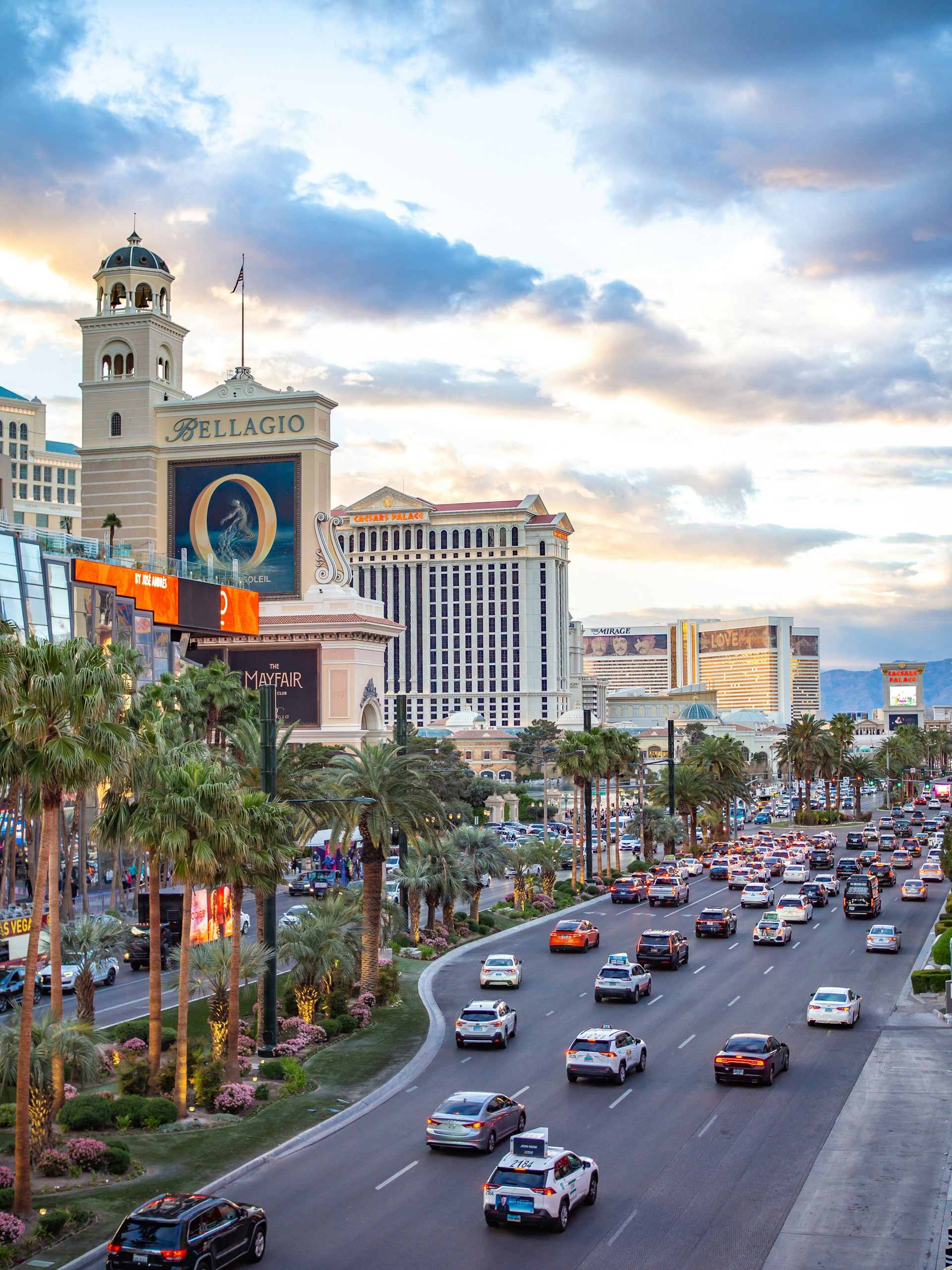 a city street filled with lots of traffic next to tall buildings