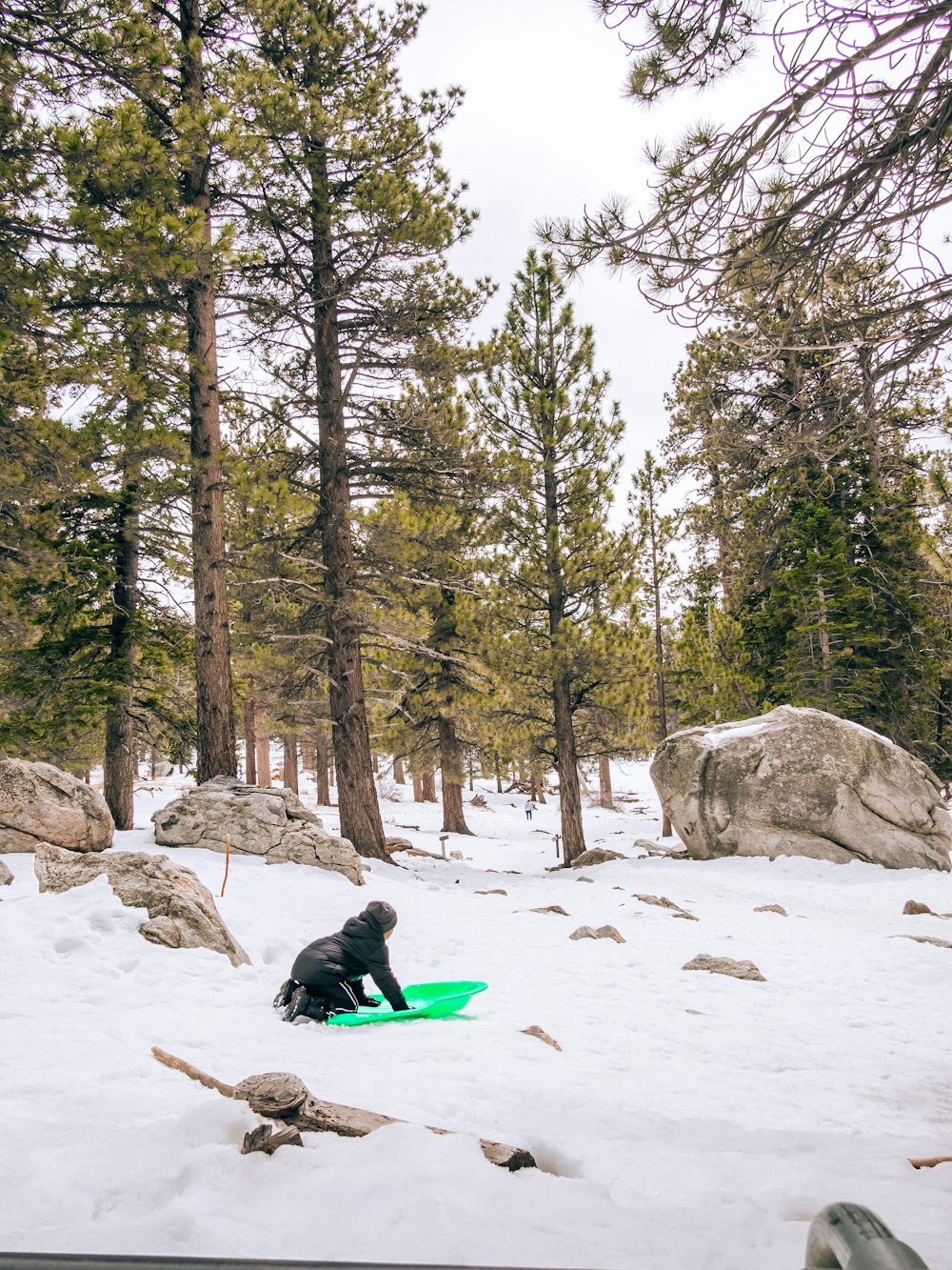 a person sitting in the snow with a surfboard
