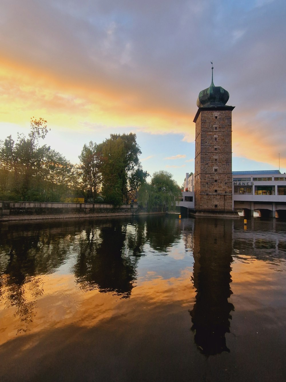 a clock tower sitting on the side of a river