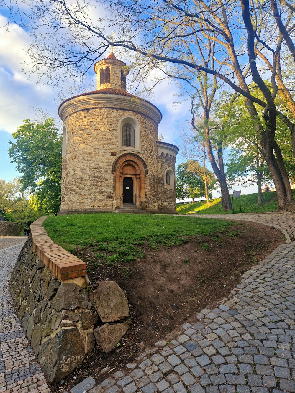 a stone building sitting on top of a lush green field