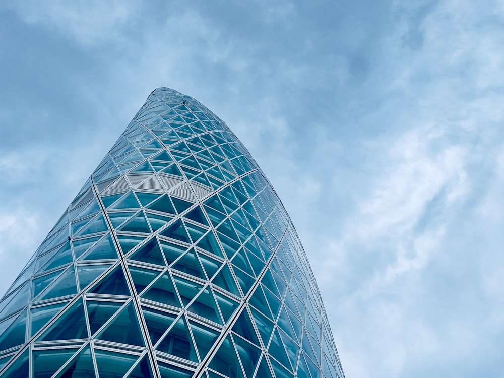 a very tall glass building with a sky background