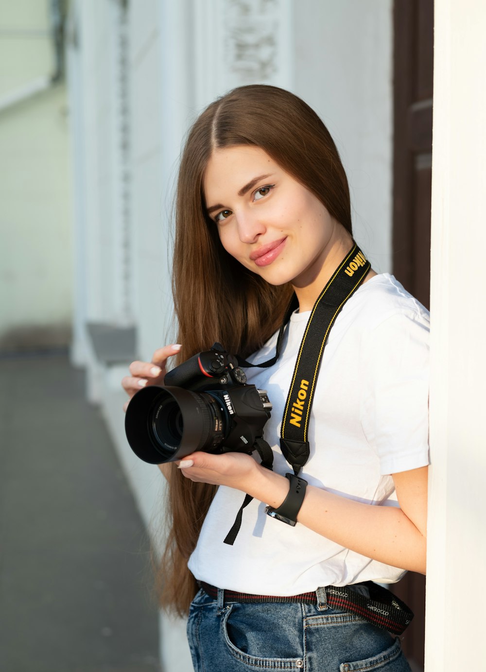 a woman holding a camera and posing for a picture