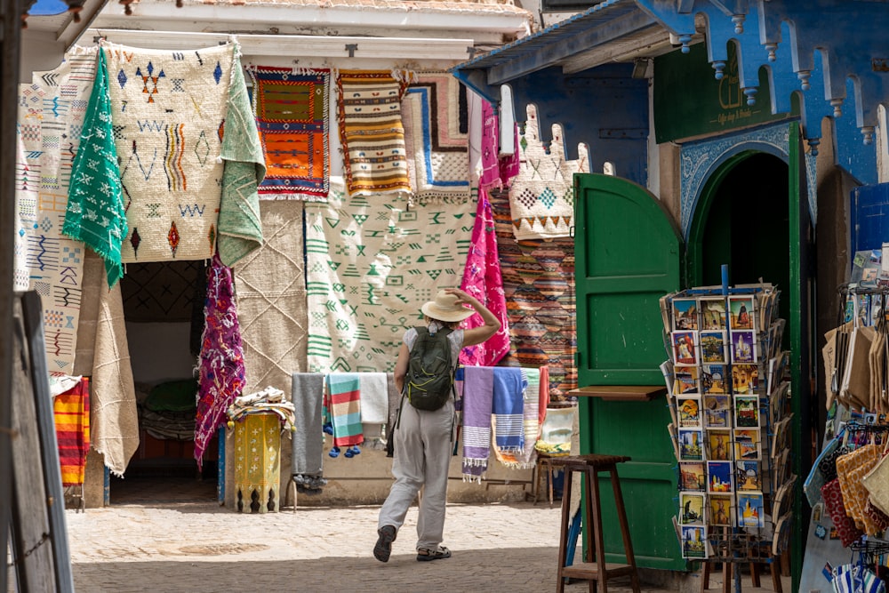 a man walking down a street next to a store