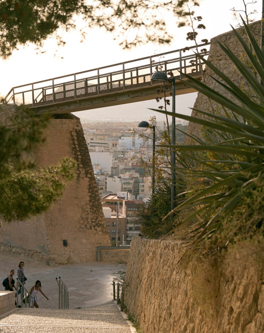 a group of people walking down a street next to a bridge