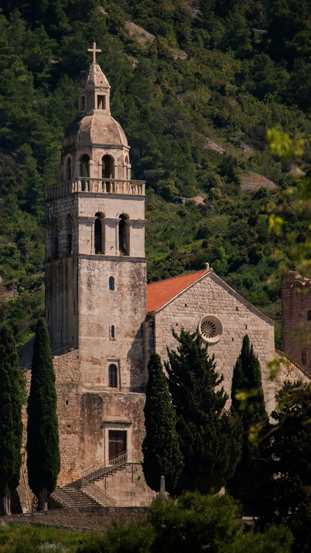 an old church with a steeple surrounded by trees