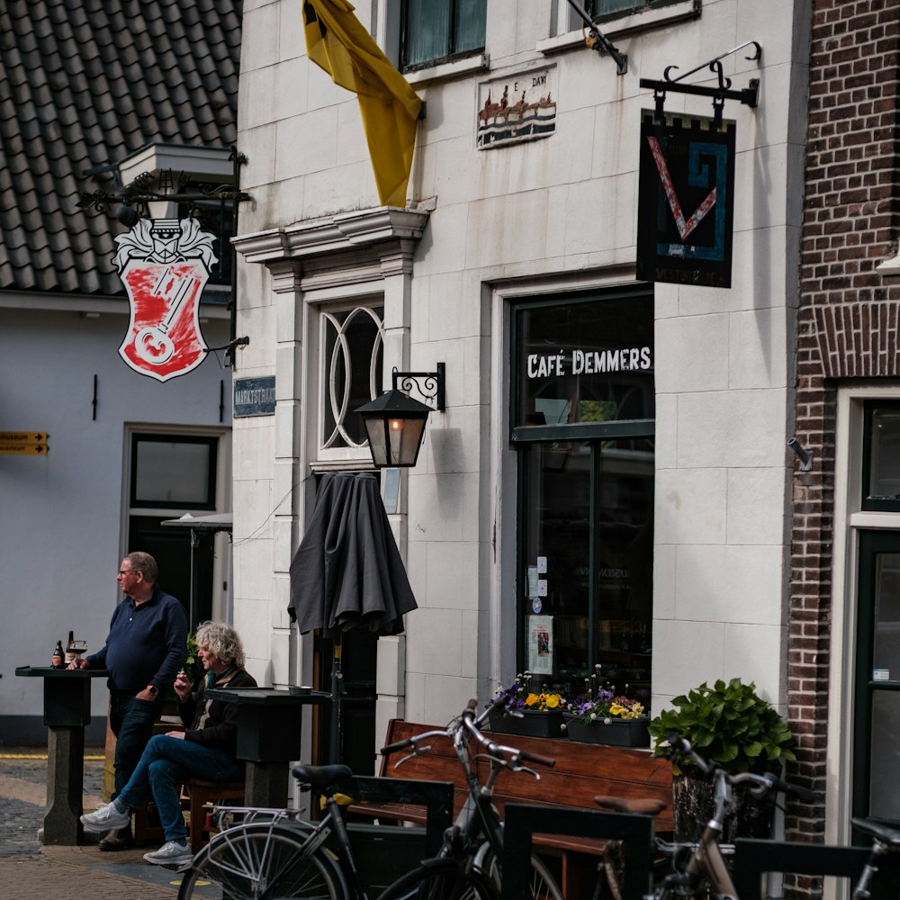 a couple of people sitting at a table outside of a building