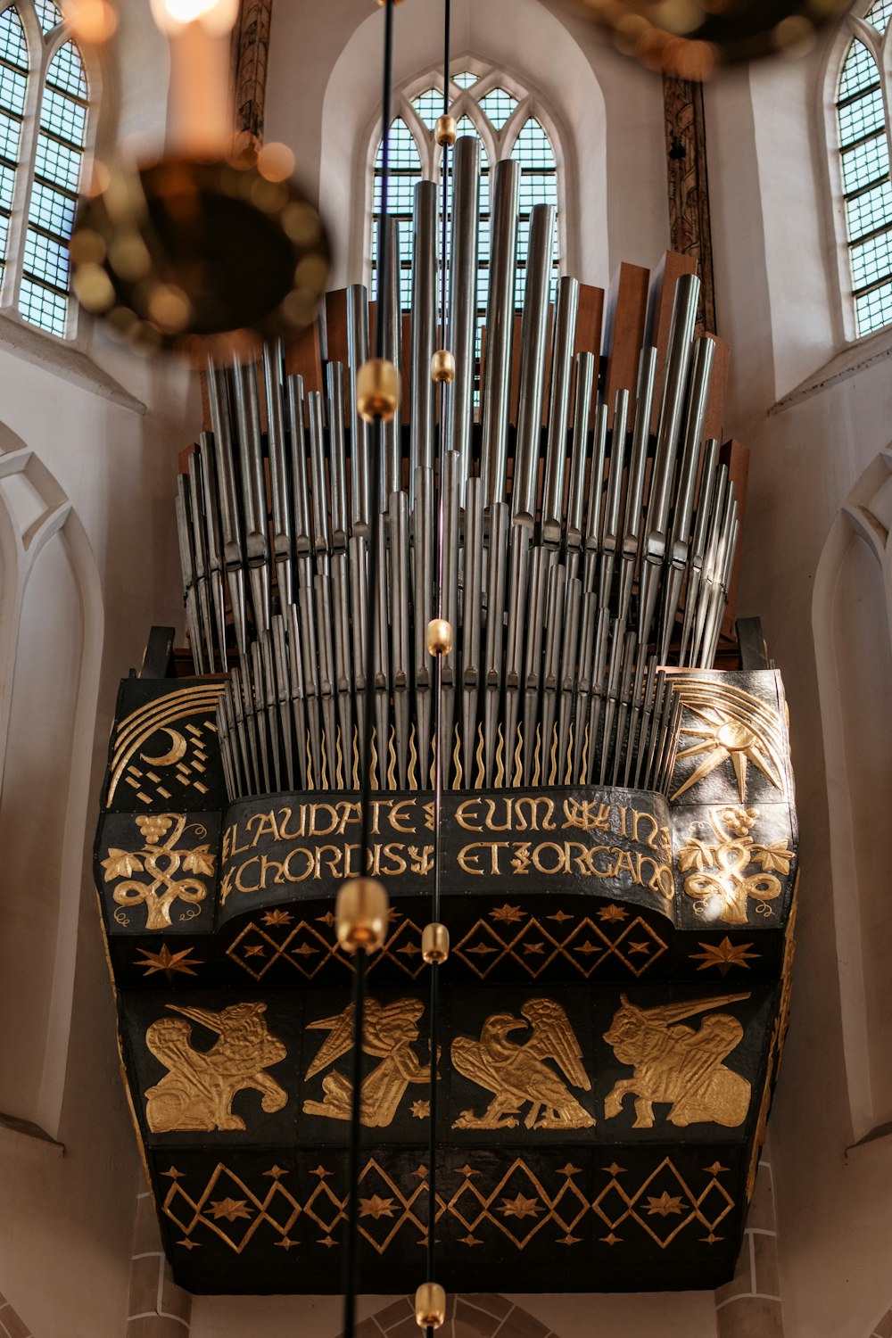 a pipe organ in a church with stained glass windows