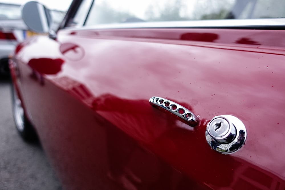 a close up of a red car door handle