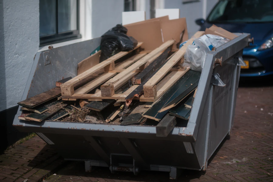 A pile of scrap lumber and renovation debris stacked beside a house