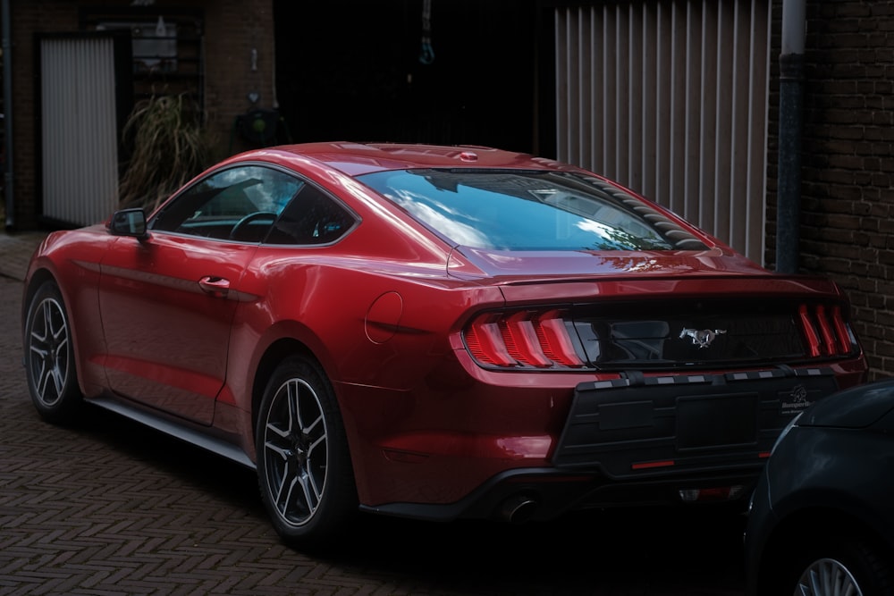 a red sports car parked in front of a brick building