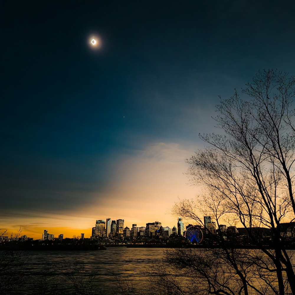 a full moon is seen in the sky over a city