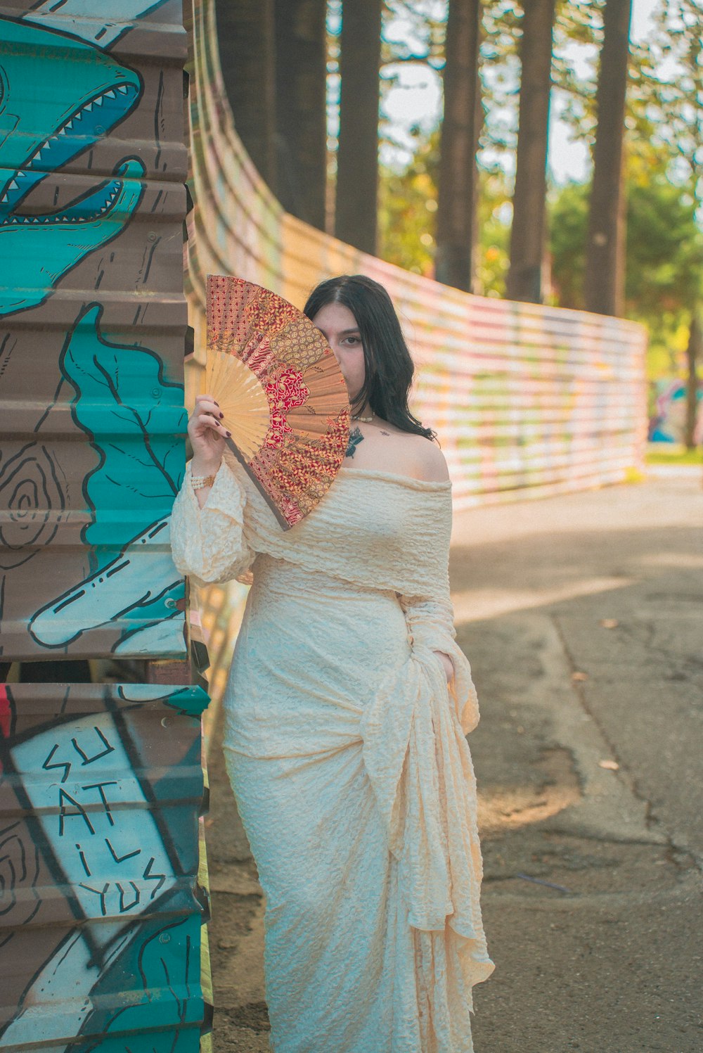 a woman in a white dress holding a fan