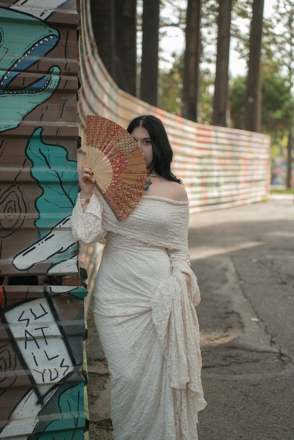 a woman in a white dress holding a fan