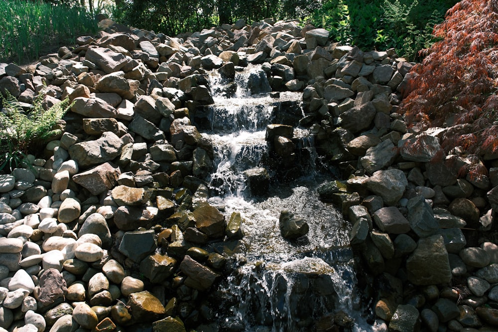 a stream of water running over rocks in a garden