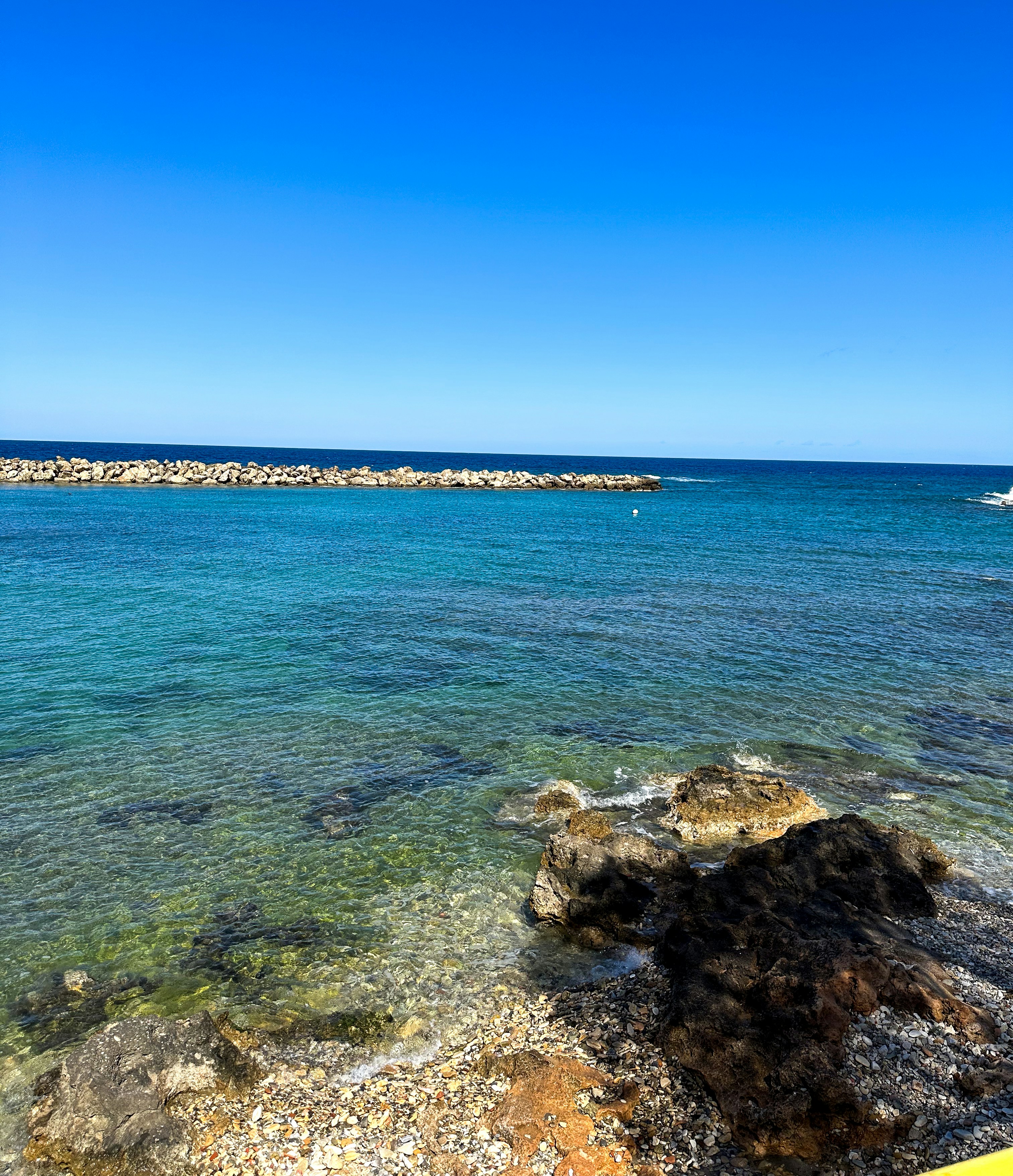 a view of the ocean from a rocky shore