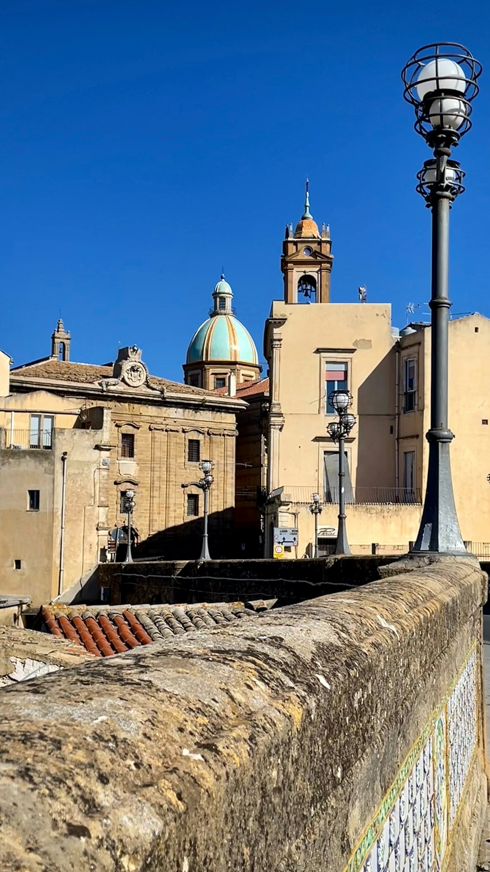 un lampione seduto sul lato di un muro