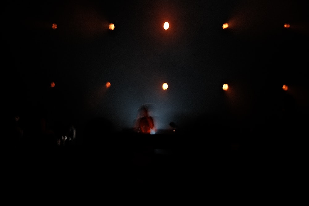 a person standing on a stage with lights in the background