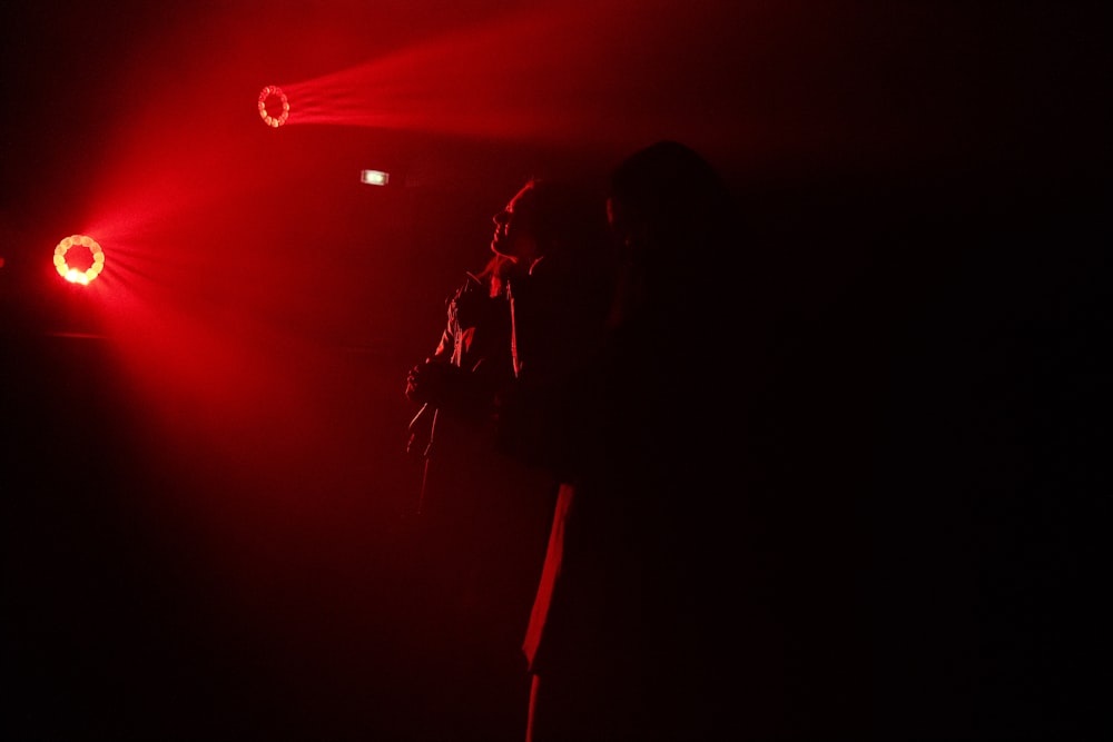 a person standing in front of a red light