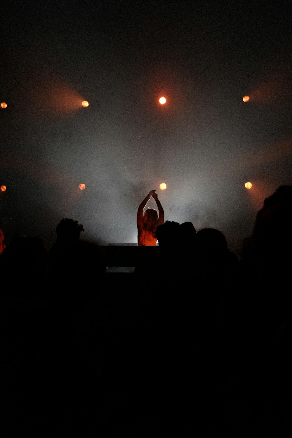 a person standing on a stage with their hands up