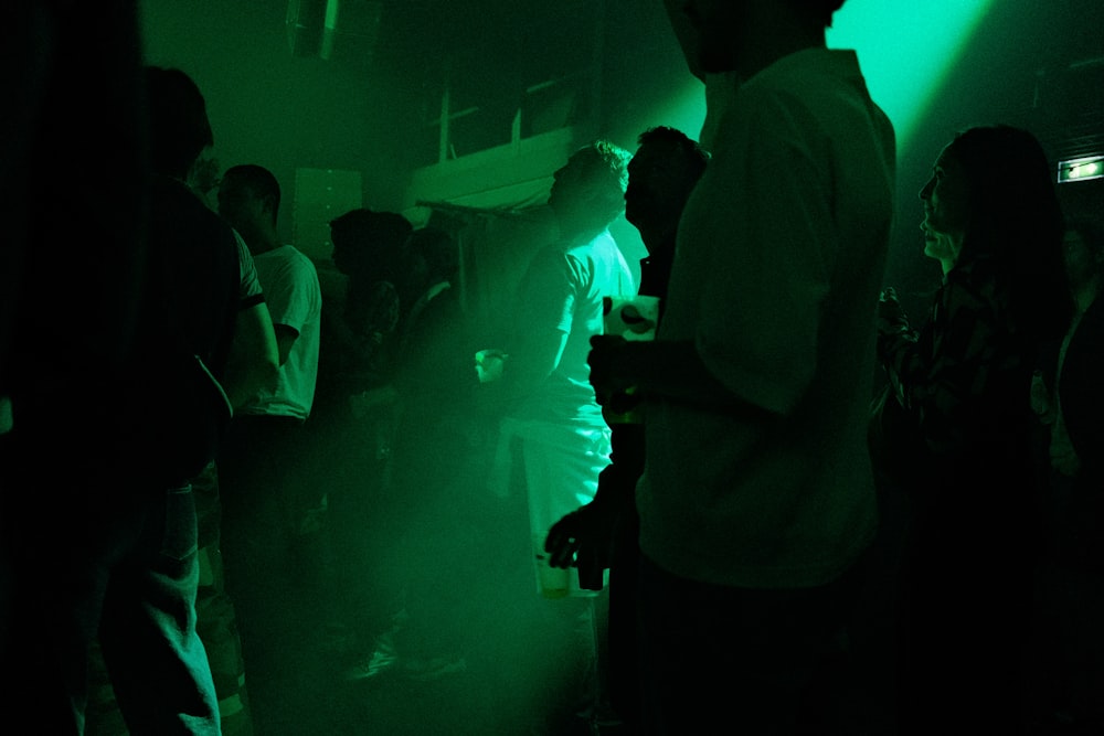 a group of people standing around in a dark room