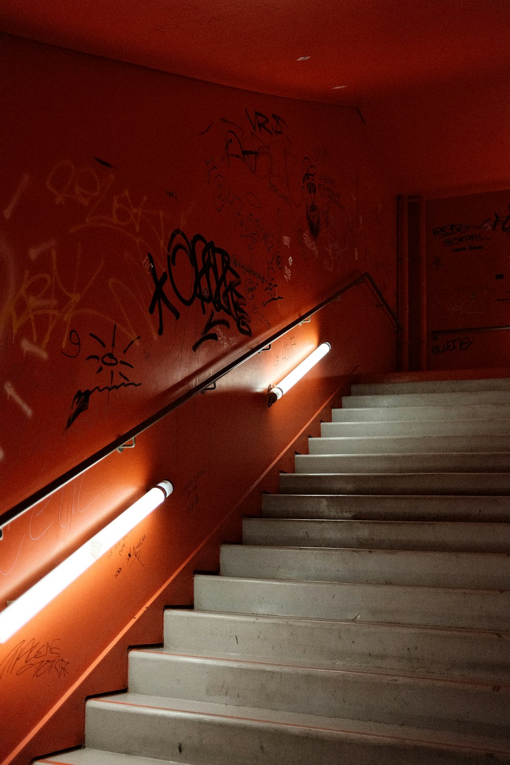 a staircase with graffiti on the wall and a light on