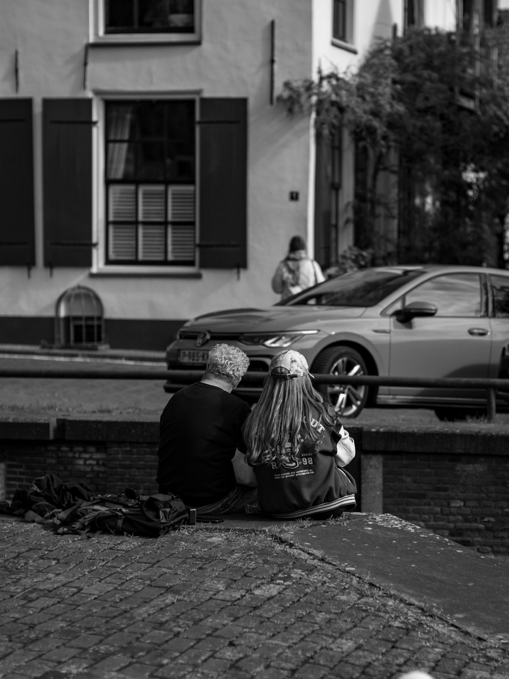 a couple of people sitting on the side of a road