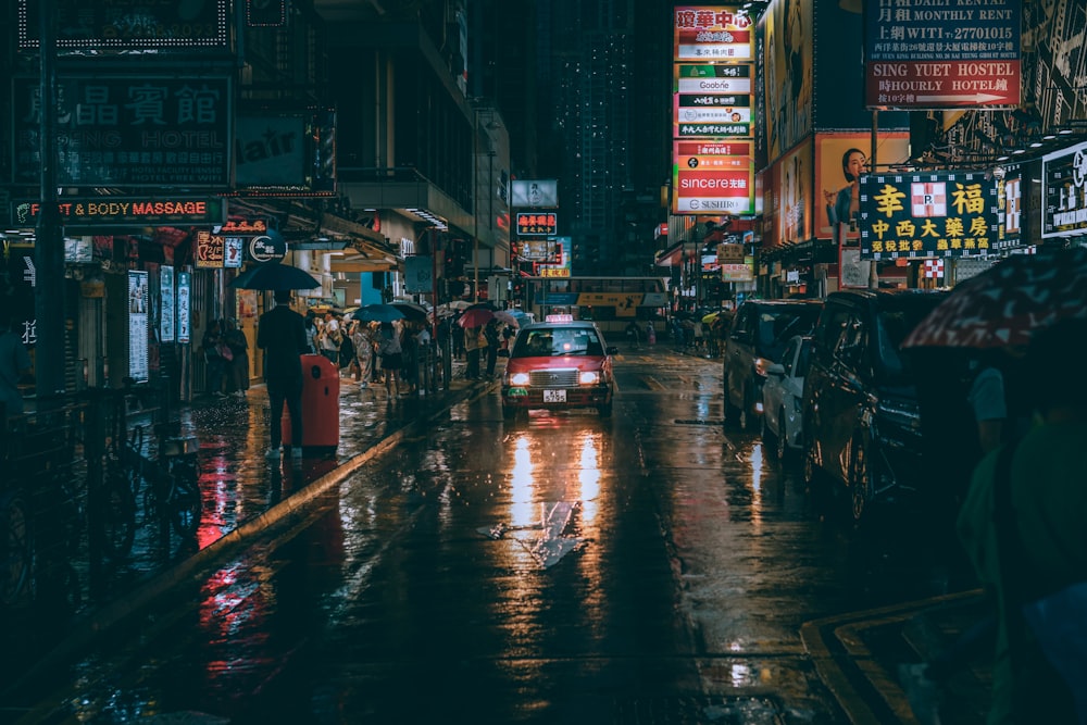 a city street at night with people and cars on it