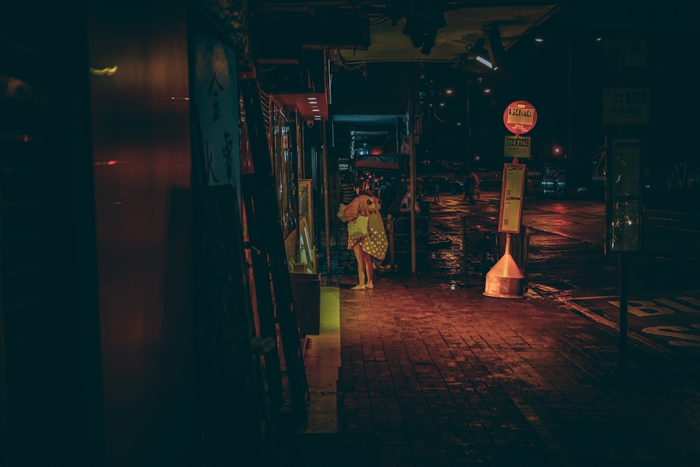 a woman walking down a street at night